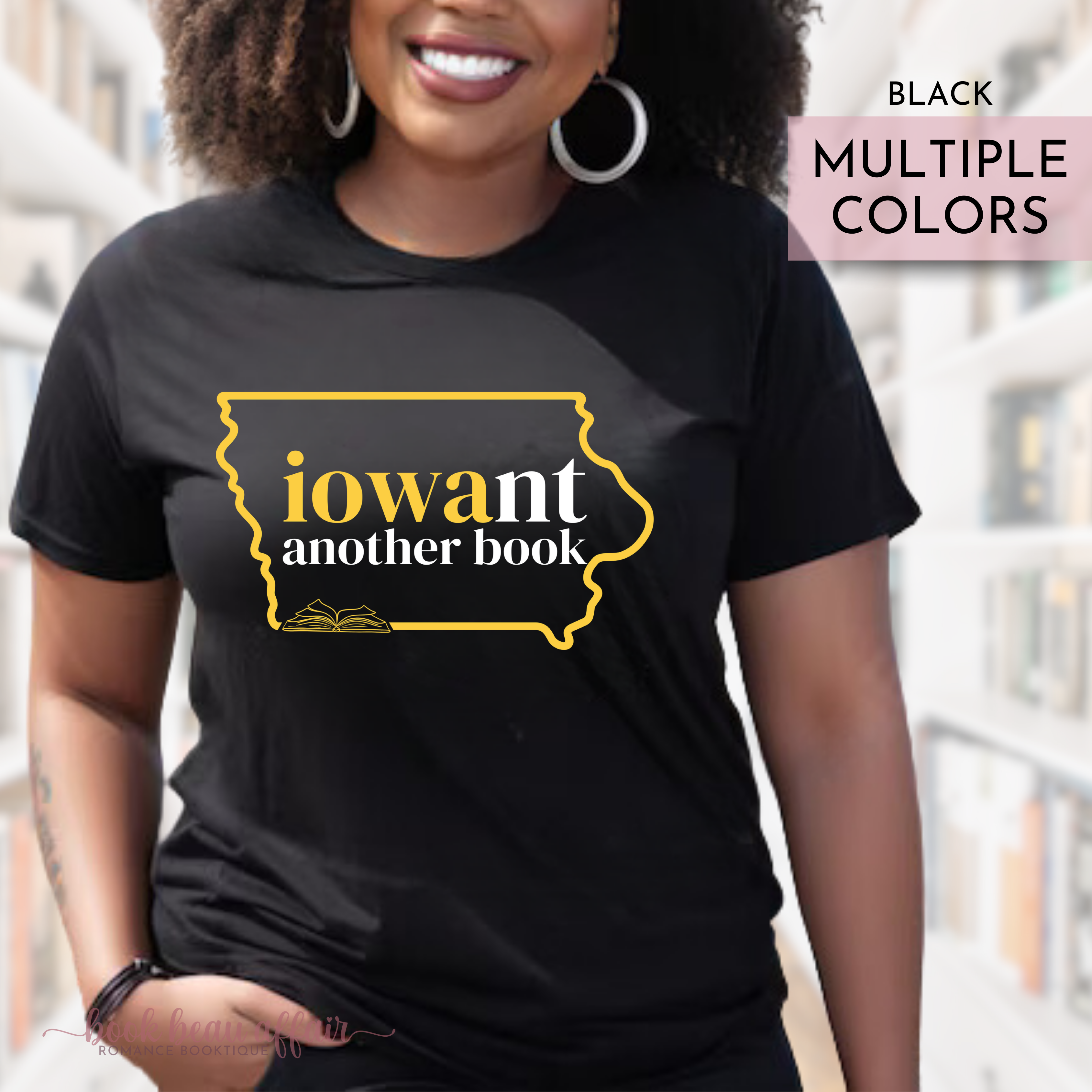 Person wearing a black t-shirt with 'iowant another book' design in Iowa Hawkeys colors, standing outdoors.