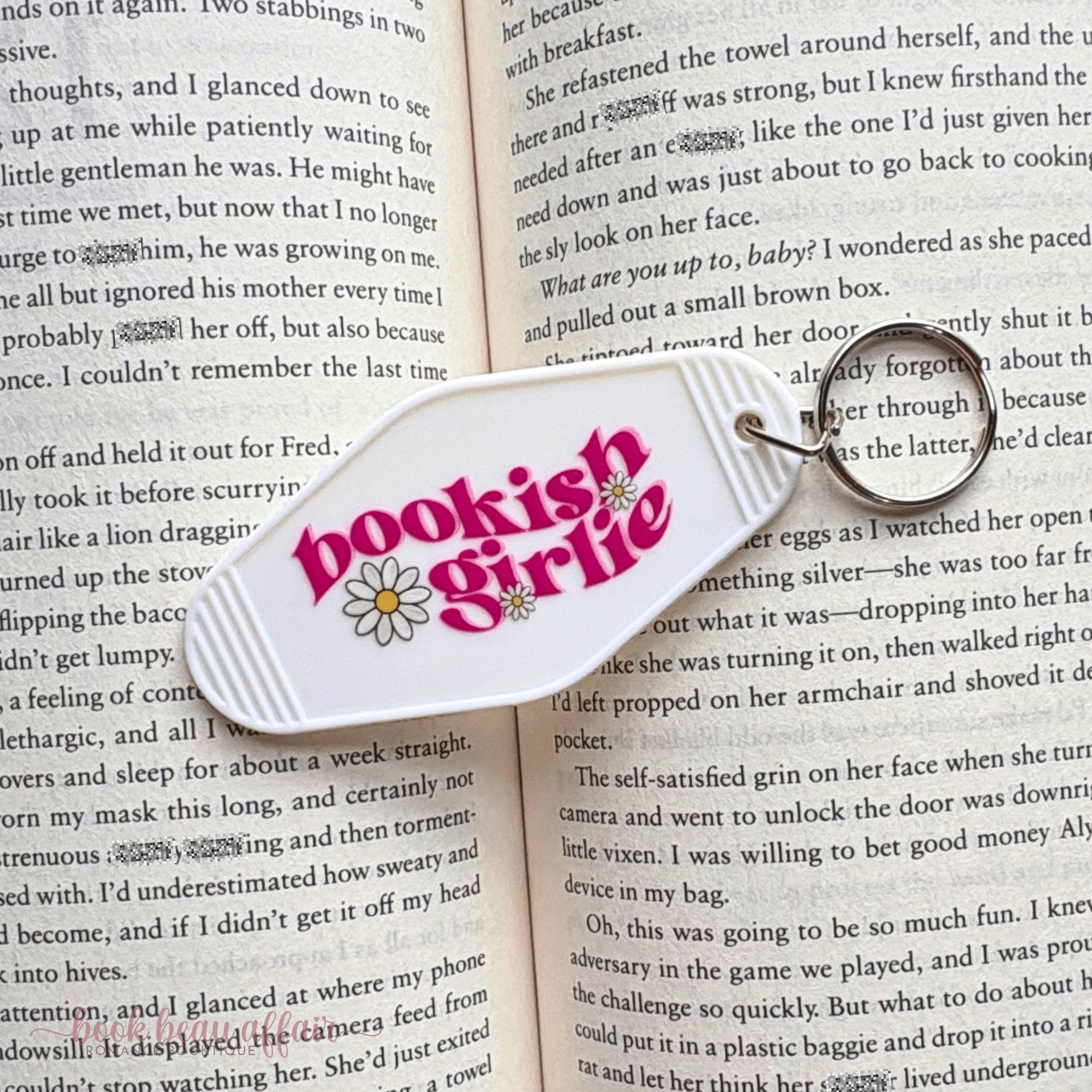 Keychain with 'bookish girl' design on an open book