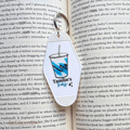 Keychain with a drink graphic and 'Tamlins Tears' text on an open book