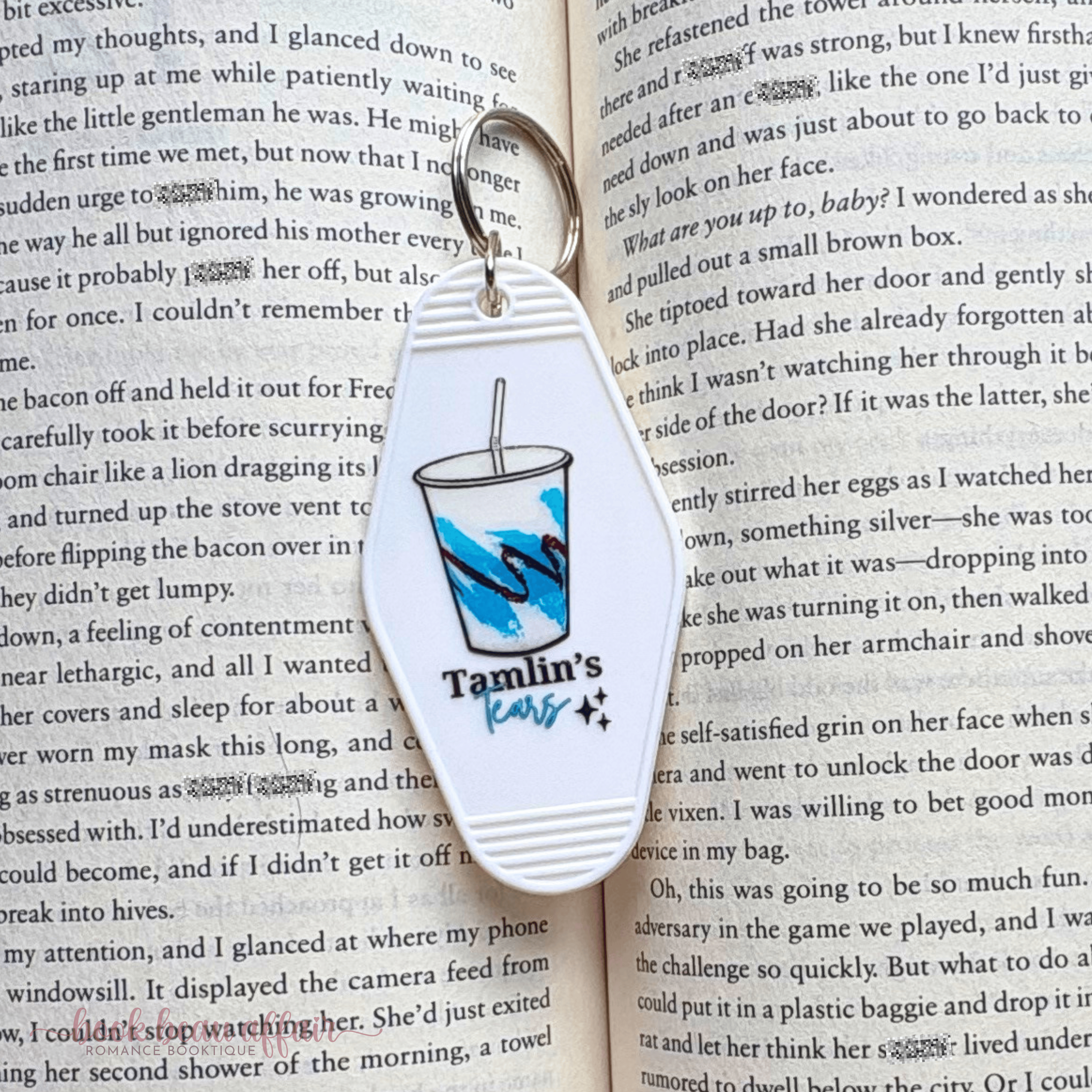 Keychain with a drink graphic and 'Tamlins Tears' text on an open book
