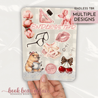 Romance themed kindle case insert that says "endless tbr" with Chanel earrings and a bottle of Prada perfume