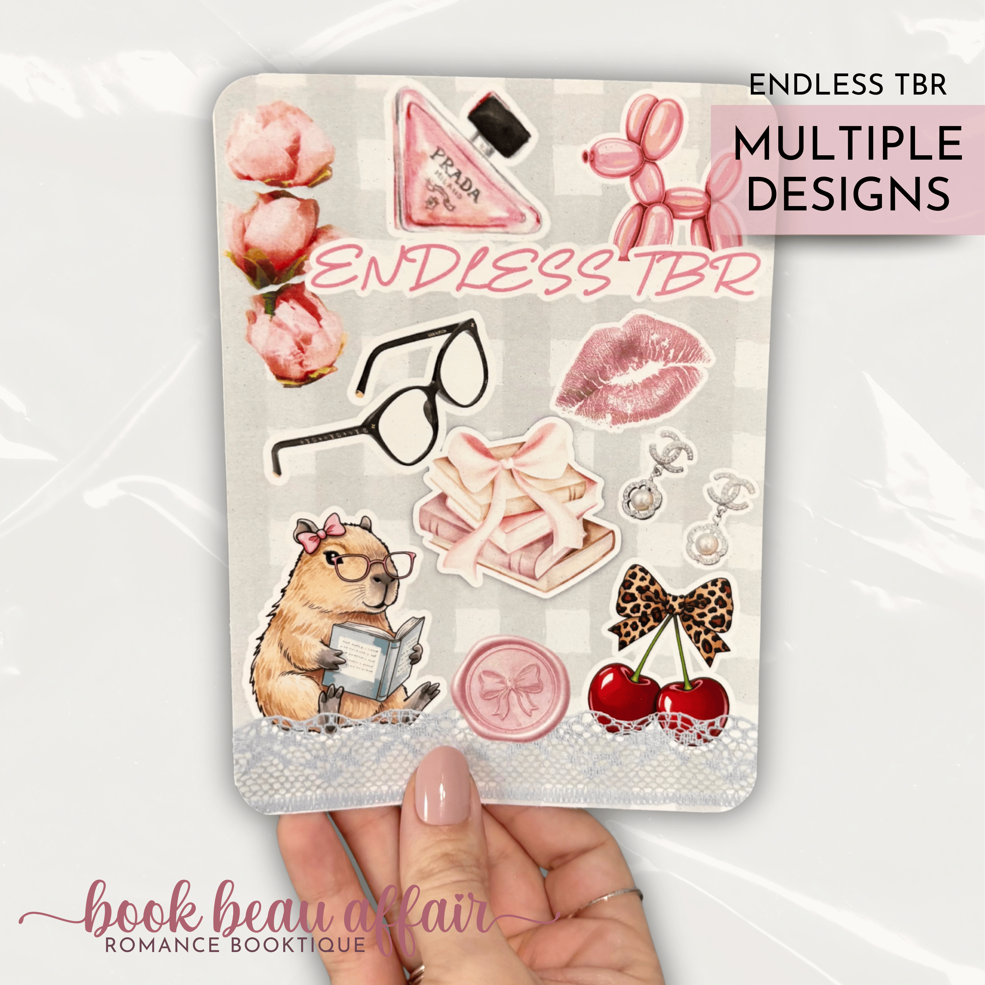 Romance themed kindle case insert that says "endless tbr" with Chanel earrings and a bottle of Prada perfume