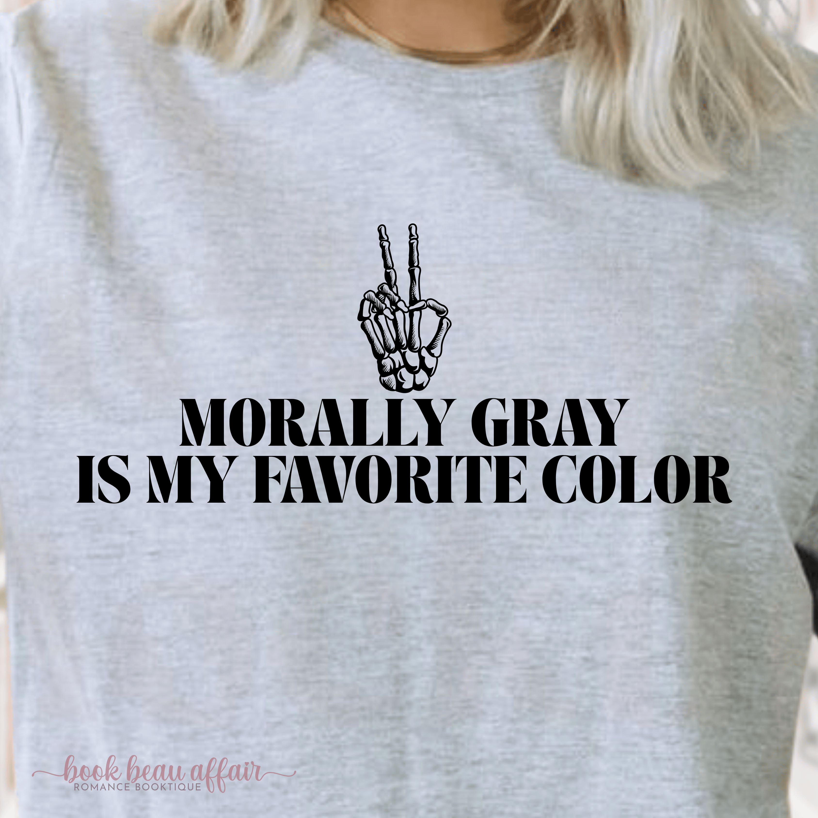 Gray sweatshirt with skeleton hand peace sign and text 'Morally Gray is my favorite color' on a blurred background.