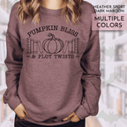 Heather dark maroon sweatshirt with 'Pumpkin Bliss & Plot Twists' text and pumpkin graphic.