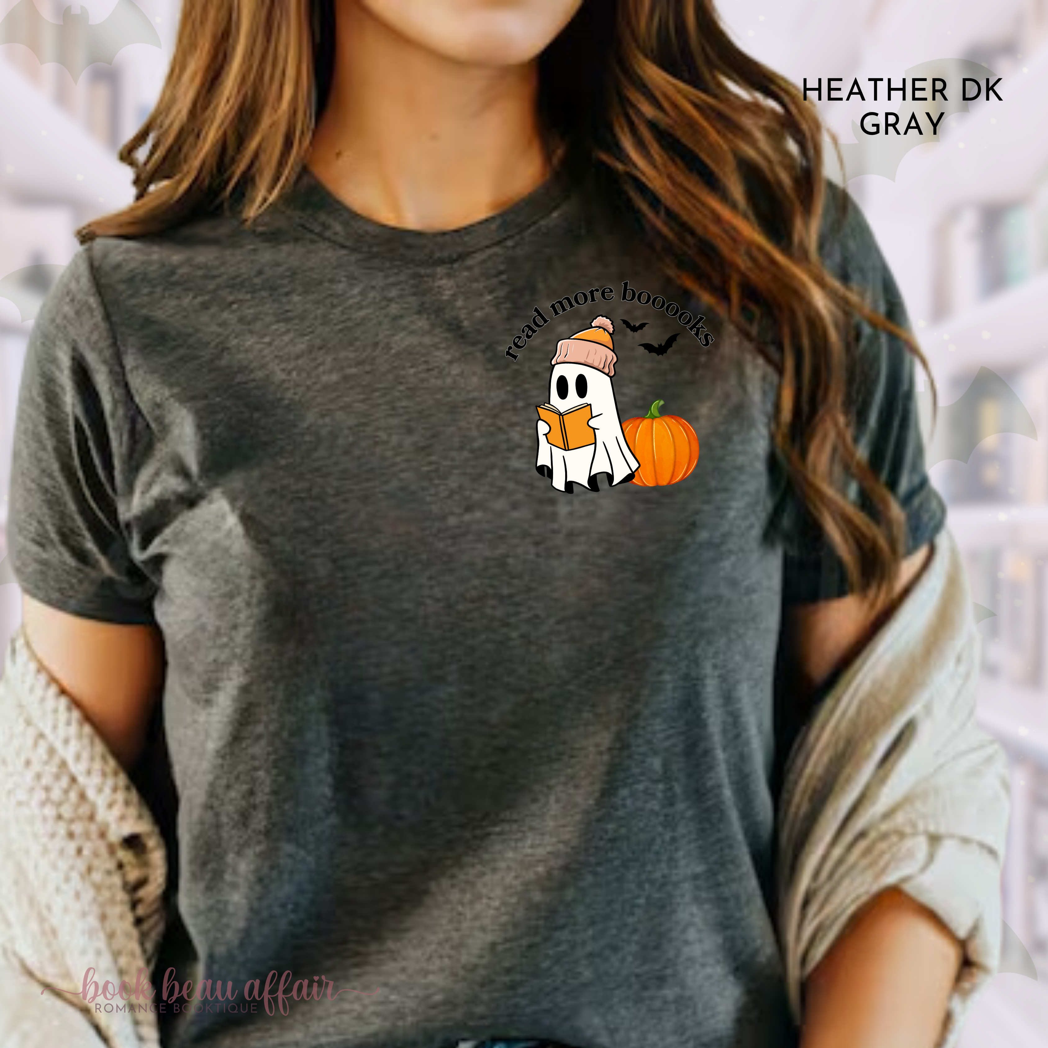 Person wearing a dark gray t-shirt with a Halloween-themed design featuring a ghost, pumpkin, and text that says Read more Booooks