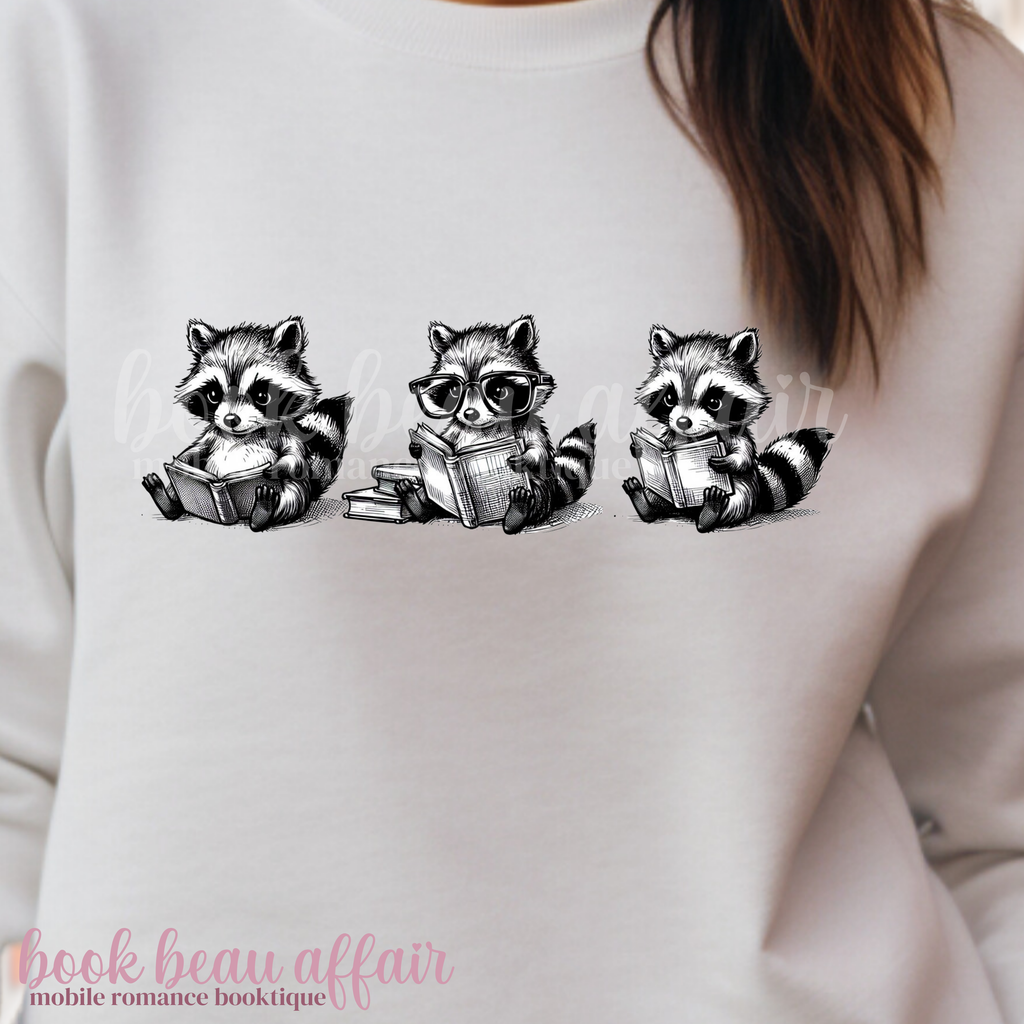 three raccoons reading