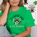 St. Patricks Day Themed Shirt. Illustration of a raccoon holding a green book with text that says "It's Good Luck to Read"